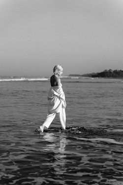 A woman in white walking in the ocean