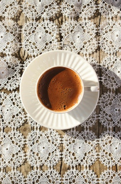 White Coffee Cup on Lace Tablecloth Flat Lay