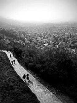 Aerial black and white view of Prizren with people walking on a path