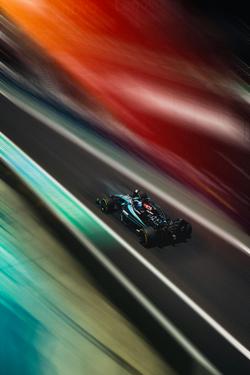 Dynamic racing car shot with vibrant colors and motion blur on a track during the day.