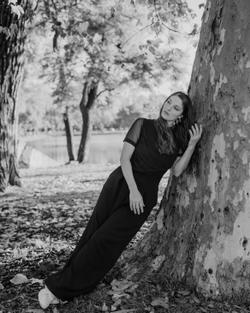 Black and white portrait of a woman leaning against a tree in Buenos Aires park.
