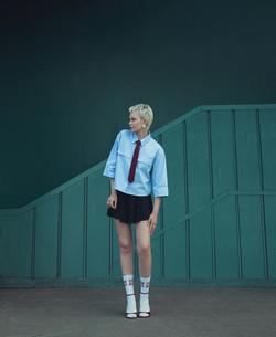 Fashionable model poses against geometric backdrop in İstanbul, embodying modern street style.