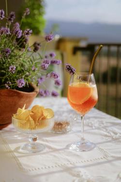 Outdoor Aperol spritz with chips on table, lavender background.