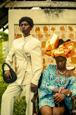 Stylish portrait of two adults in vibrant traditional African attire outdoors.