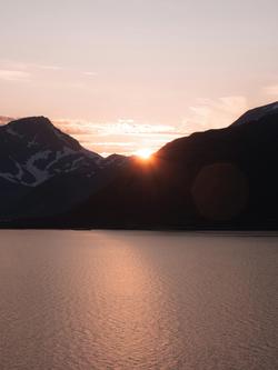 Stunning view of the sunset over majestic Norwegian fjords with vibrant hues.
