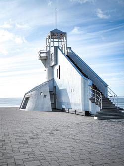 Striking blue sky frames a modern white lighthouse in Oulu, Finland.