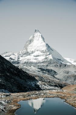 Stunning view of the iconic Matterhorn mountain reflecting in a tranquil alpine lake in Zermatt, Switzerland.