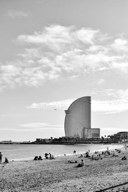 Black and white image of Barcelona beach with W Hotel and scattered people enjoying the day.